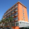 Edificio arancione con balconi e palme, cielo blu sullo sfondo.