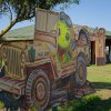 Cartonato di tartaruga su jeep gialla in un prato.