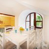 Sala da pranzo luminosa con tavolo bianco e sedie.