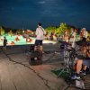 Concerto serale accanto a una piscina illuminata.