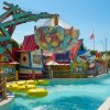 Attrazione acquatica colorata con piscina e gommoni gialli.